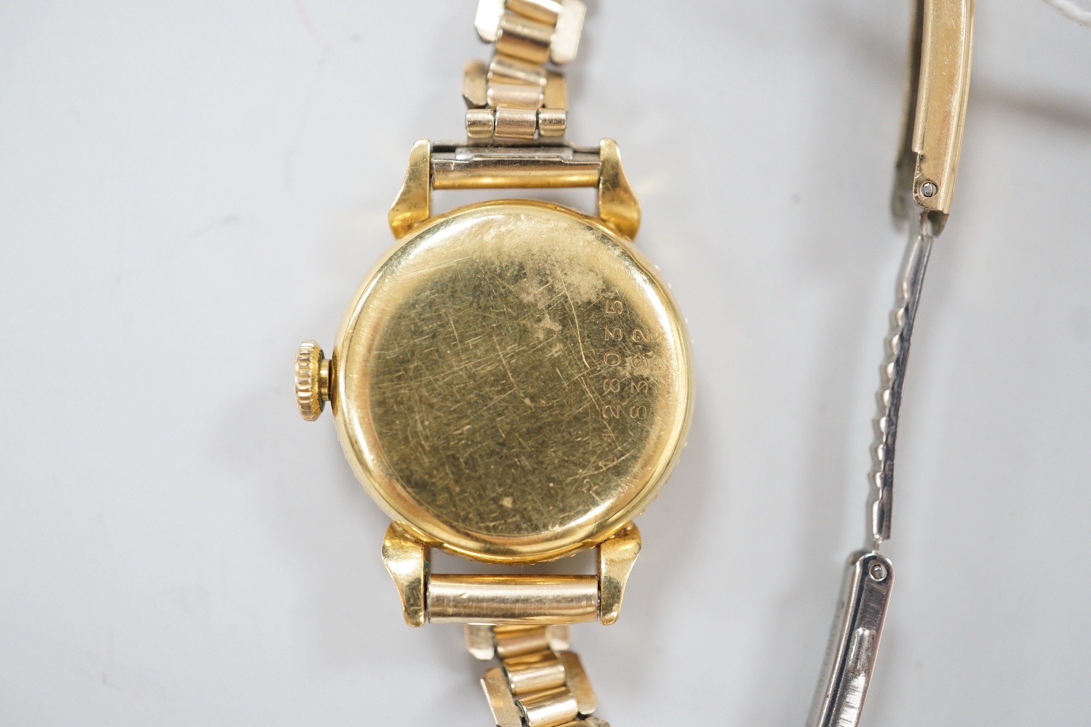 A lady's 750 yellow metal Universal manual wind wrist watch, on associated gold plated bracelet.